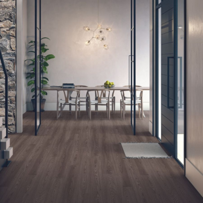 Warm dark brown wood-look laminate flooring in a modern dining room with glass doors and a light wood table.